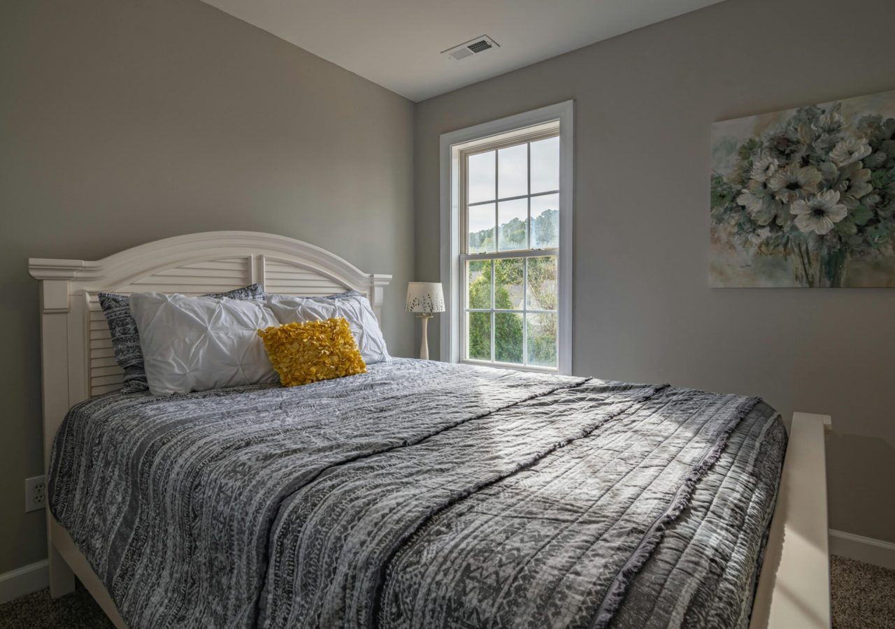 A warm, inviting bedroom with a double bed and natural light streaming in.